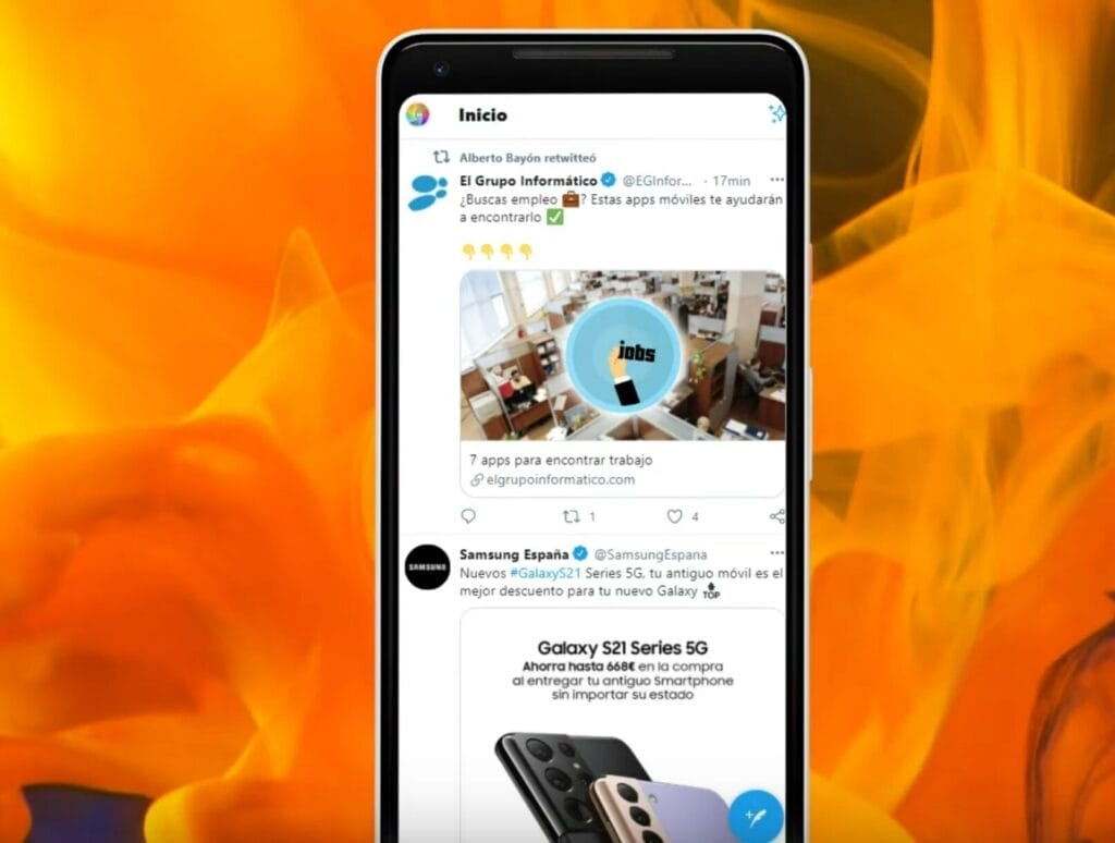 La pantalla de un teléfono inteligente muestra un feed de redes sociales con publicaciones en español. Una publicación muestra un espacio de trabajo en una oficina, otra promociona el Samsung Galaxy S21 Series 5G y una tercera explica cómo bloquear un usuario en Twitter.