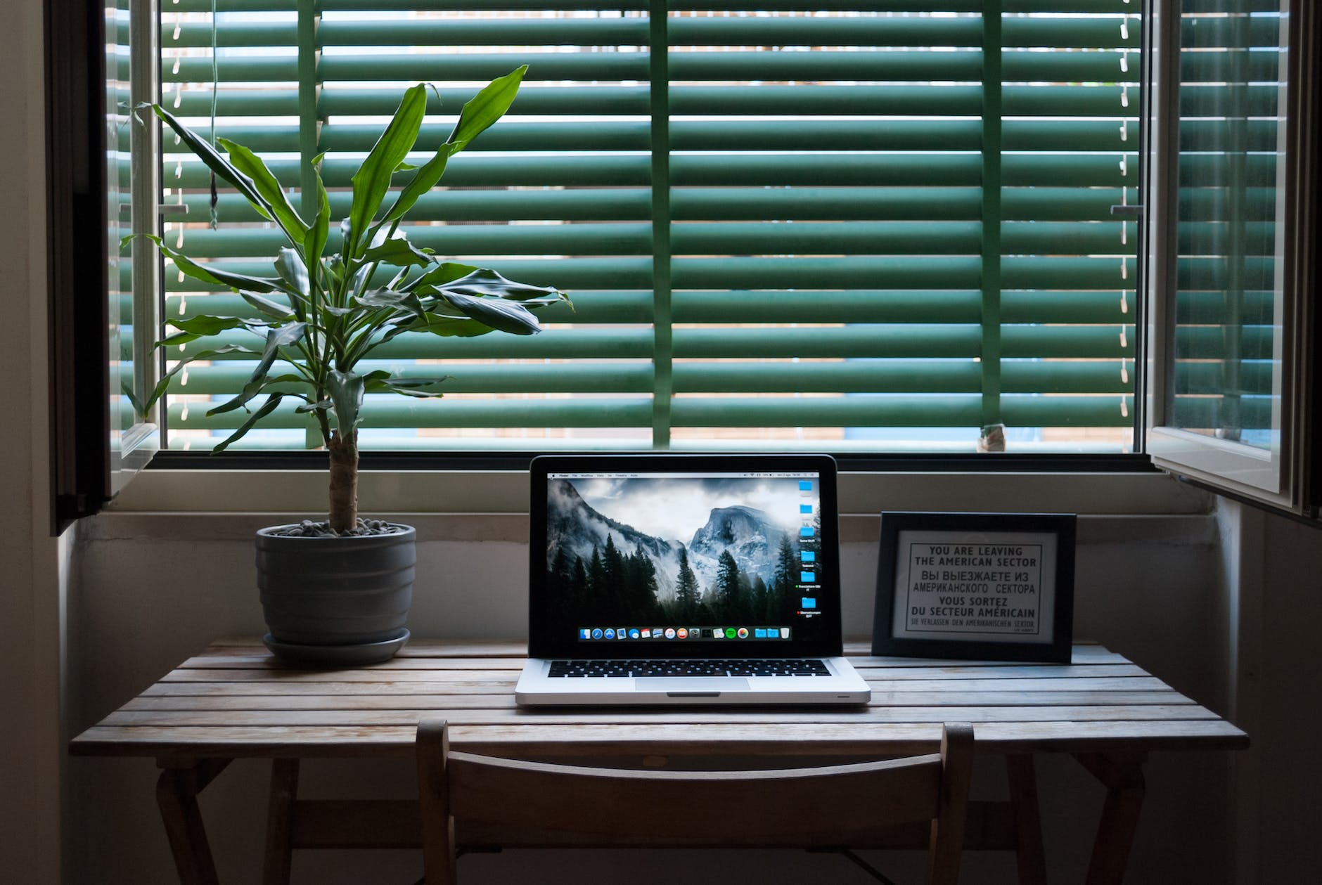 Copia de seguridad de Windows photo of macbook air on a table next to house plant and picture frame